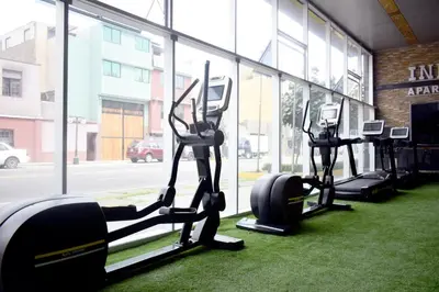 a row of tread machines in a gym with a window at Inkari Apart Hotel in Lima