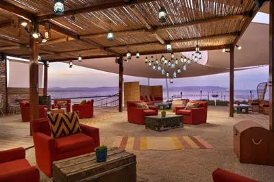 a living room with red furniture and a view of the ocean at The Legend Paracas Resort, a Destination by Hyatt Hotel in Paracas
