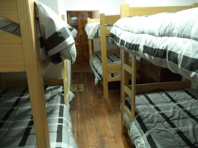 a room with three bunk beds in a house at Gringo's Wasi in Cusco