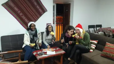 a group of women sitting on a couch eating food at Gringo's Wasi in Cusco