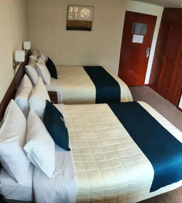 a hotel room with two beds with pillows at Hotel Carmel in Lima