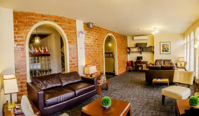 a living room with leather furniture and a brick wall at Hotel Carmel in Lima