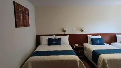 two beds in a room with blue and white at Hotel Carmel in Lima