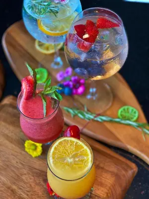 a wooden cutting board with two cocktails and strawberries at Habitat Hotel in Lima