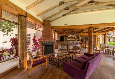 a living room with a fireplace and a couch at Hotel La Casona De Yucay Valle Sagrado in Urubamba