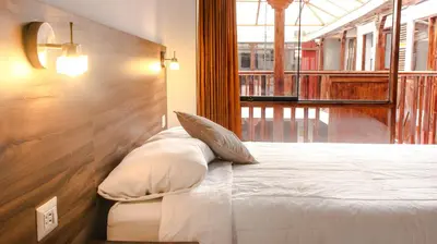 a bed with two pillows on it in a room at SAN BLAS PLAZA INn in Cusco
