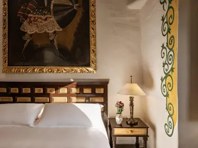 a bedroom with a bed and a painting on the wall at Monasterio, A Belmond Hotel, Cusco in Cusco