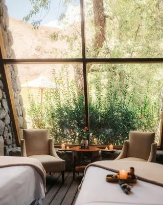 a room with two beds and a large window at Rio Sagrado, A Belmond Hotel, Sacred Valley in Urubamba