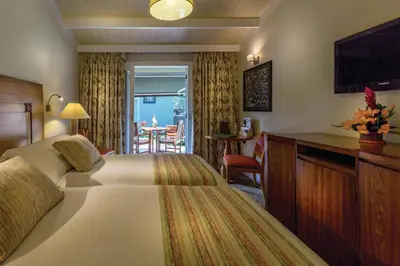 a hotel room with a large bed and a table at Sanctuary Lodge, A Belmond Hotel, Machu Picchu in Machu Picchu
