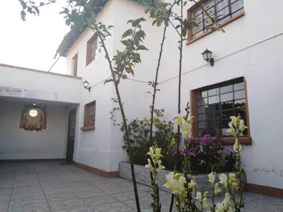 a white building with flowers in the courtyard at Pousada Villa Huaripampa in Jauja