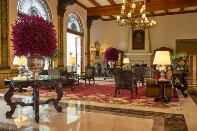a lobby with chairs and a vase with flowers in it at Country Club Lima Hotel – The Leading Hotels of the World in Lima