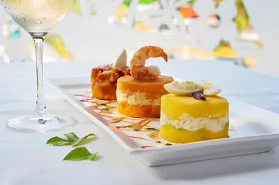 a plate of desserts on a table with a glass of wine at Country Club Lima Hotel – The Leading Hotels of the World in Lima