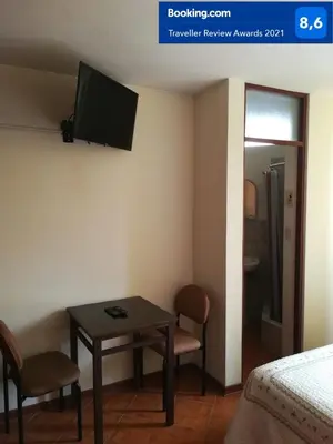 a room with a table and a tv on the wall at Tambo Huascar in Lima