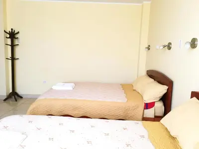 a bedroom with two beds and a cross on the wall at Sandel in Barranca