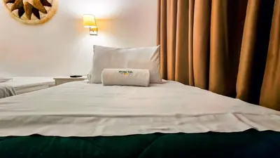 a white bed with a pillow on top of it at Hotel Riviera Inka Paracas in Paracas