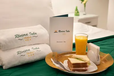a plate with a sandwich and a glass of orange juice at Hotel Riviera Inka Paracas in Paracas