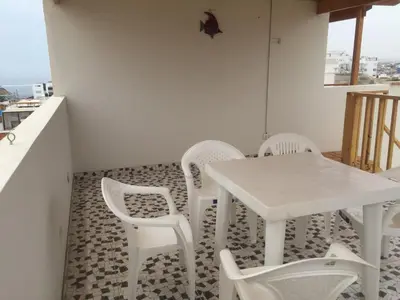 a white table and white chairs in a room at Departamentos Playa San Bartolo in San Bartolo