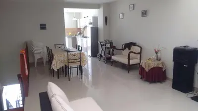 a living room with a table and chairs and a kitchen at Departamentos Playa San Bartolo in San Bartolo