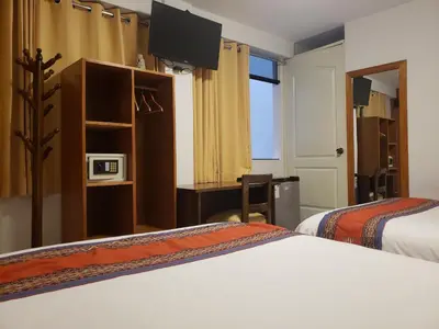 a hotel room with two beds and a tv at Mantu Boutique in Machu Picchu