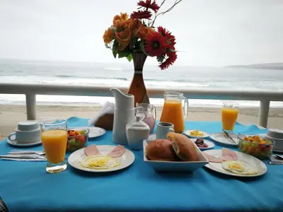 a blue table with breakfast food and orange juice at Meflo Playa Grande in Chala
