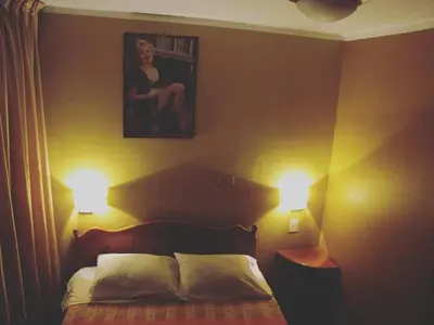 a bedroom with a bed with two lights on it at Prince Hospedaje in Ayacucho