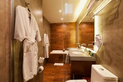 a bathroom with a toilet and a sink and a tub at Inti Punku Machupicchu Hotel & Suites in Machu Picchu
