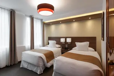 a hotel room with two beds and a light at Inti Punku Machupicchu Hotel & Suites in Machu Picchu