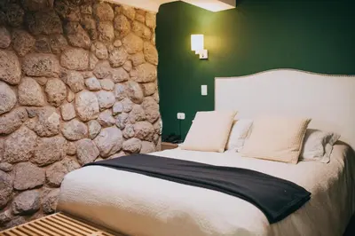 a bedroom with a large bed with a stone wall at Anden Inca Hotel in Cusco