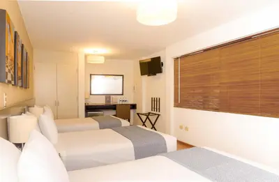 a hotel room with two beds and a television at Girasoles Hotel in Lima