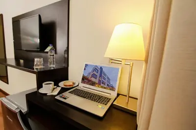 a laptop computer sitting on a desk with a lamp at Girasoles Hotel in Lima