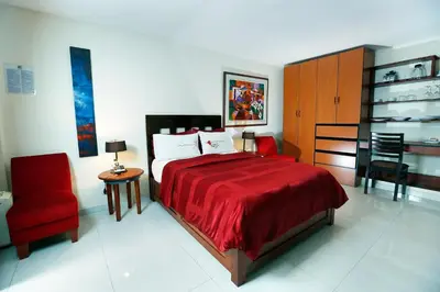 a bedroom with a red bed and a red chair at Peru Star Apart-Hotel in Lima