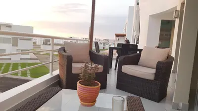 a balcony with two chairs and a potted plant at Condominio Las Terrazas in Asia