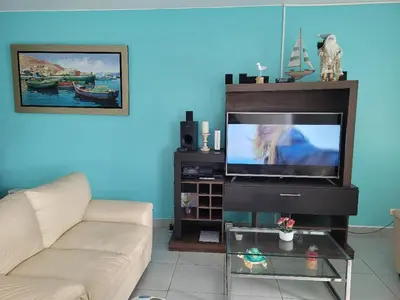 a living room with a couch and a flat screen tv at Condominio Las Terrazas in Asia