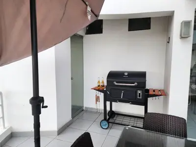 a grill in a room with a table and chairs at Condominio Las Terrazas in Asia