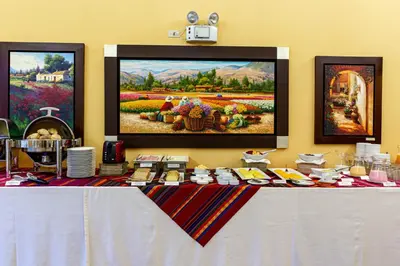 a table with food on top of it with paintings at LP Los Portales Hotel Tarma in Tarma