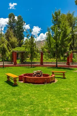 two benches and a fire pit in a park at LP Los Portales Hotel Tarma in Tarma