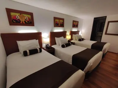 a hotel room with three beds in a room at Hotel Ferré Boulevard in Machu Picchu