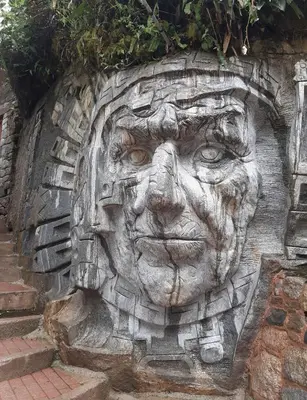 a statue of a face on the side of a building at Hotel Ferré Boulevard in Machu Picchu