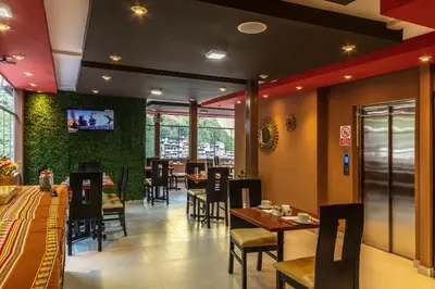 a dining room with tables and chairs in a restaurant at Hotel Ferré Boulevard in Machu Picchu
