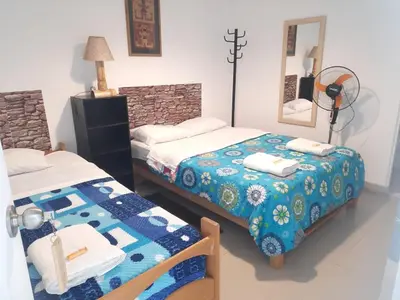 a bedroom with two beds and a mirror at Hostal Brisa Marina in Paracas