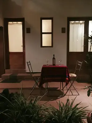 a table with a bottle of wine and two chairs at Kutty Wasi in Cusco