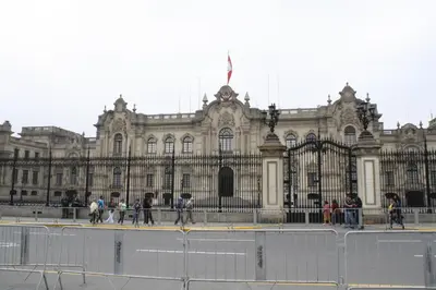 a large building with people walking in front of it at Main Square in Lima