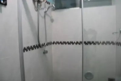 a bathroom with a shower with a glass door at Main Square in Lima