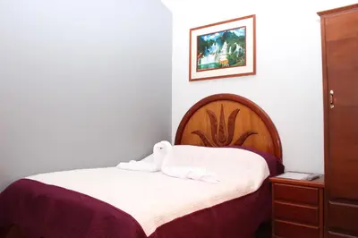 a bedroom with a bed with two towels on it at Hostal Las Fresas Lima Airport in Lima