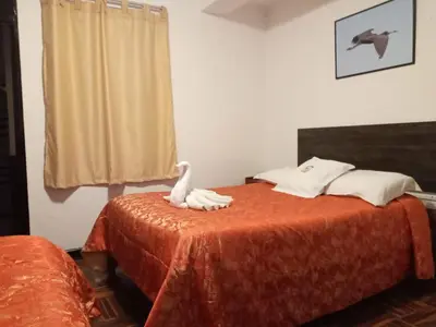 a bedroom with a bed with a white bird on it at Qoricancha B&B Cusco in Cusco