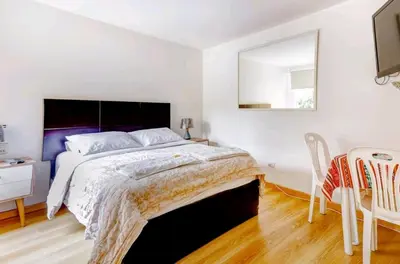 a bedroom with a large bed and a table and chairs at Green House in Lima
