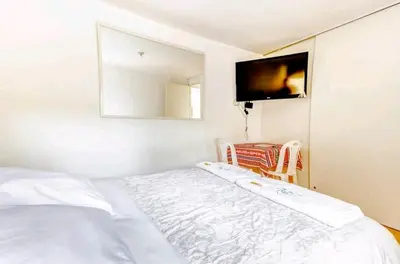 a bedroom with a bed and a tv on the wall at Green House in Lima