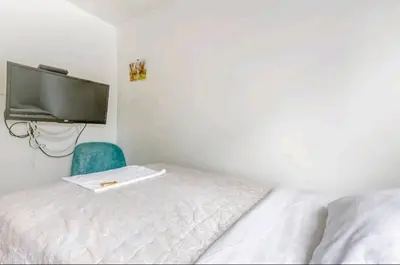 a small bedroom with a bed and a tv at Green House in Lima
