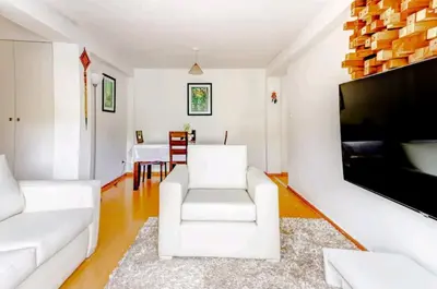 a living room with a white couch and a flat screen tv at Green House in Lima