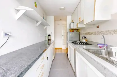 a white kitchen with white cabinets and a sink at Green House in Lima